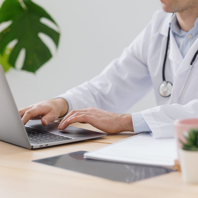 telemedicine-doctor-in-a-white-coat-and-glasses-communicates-with-a-patient-doctor-fills-out-a_t20_RJmXEm.jpg